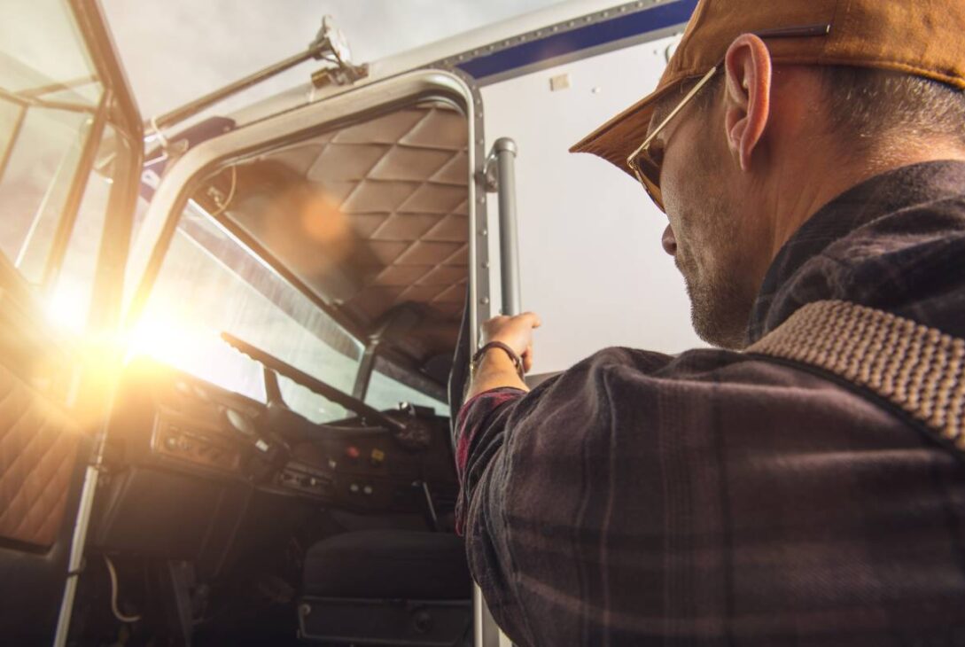 Professional Caucasian Truck Driver in His 40s Getting Into His Truck Cabin. Heavy Duty Transportation Theme. CDL Drive.