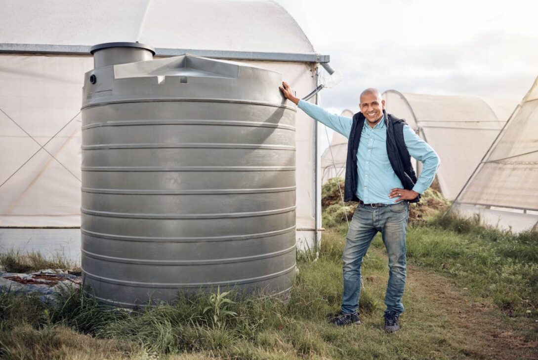 Man, portrait and water tank in farming liquid or soil hydration for vegetables, food and crops gro.