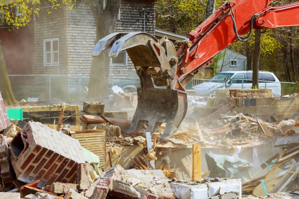 Demolition of an old house, wooden planks and rubble and the ruins of the house for new construction project.