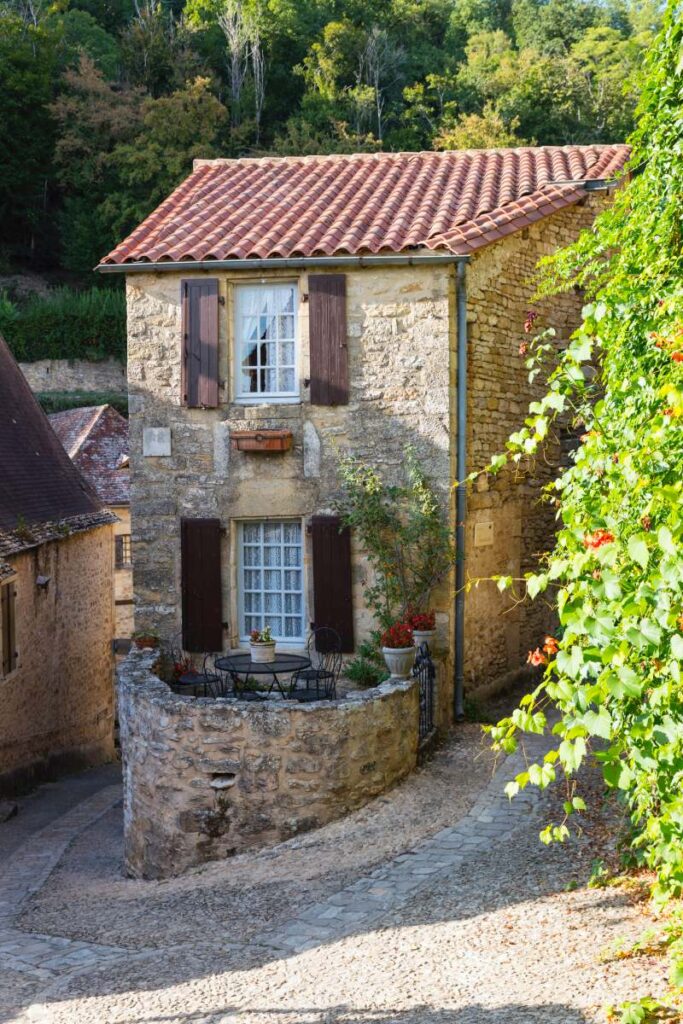 typical old limestone house in beynac in the Dordogne in France with nature with trees in the background