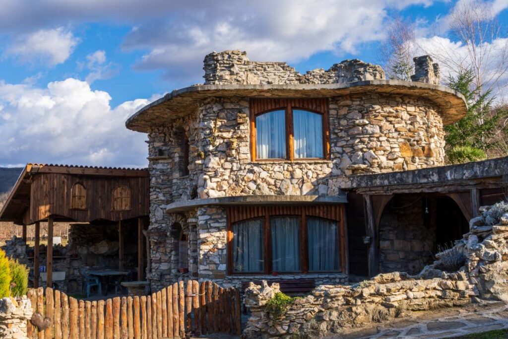 Stone cottage in Croatia with mountain view, fenced yard, and lush foliage