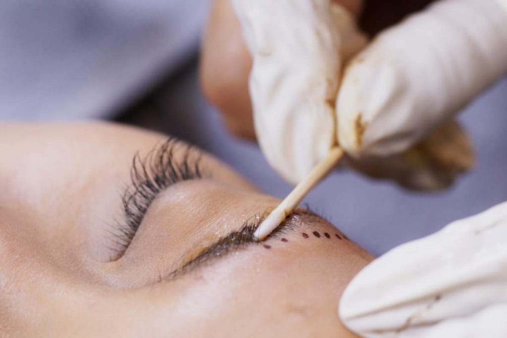 Beautician specialist of permanent makeup making brow microblading tattooing make up