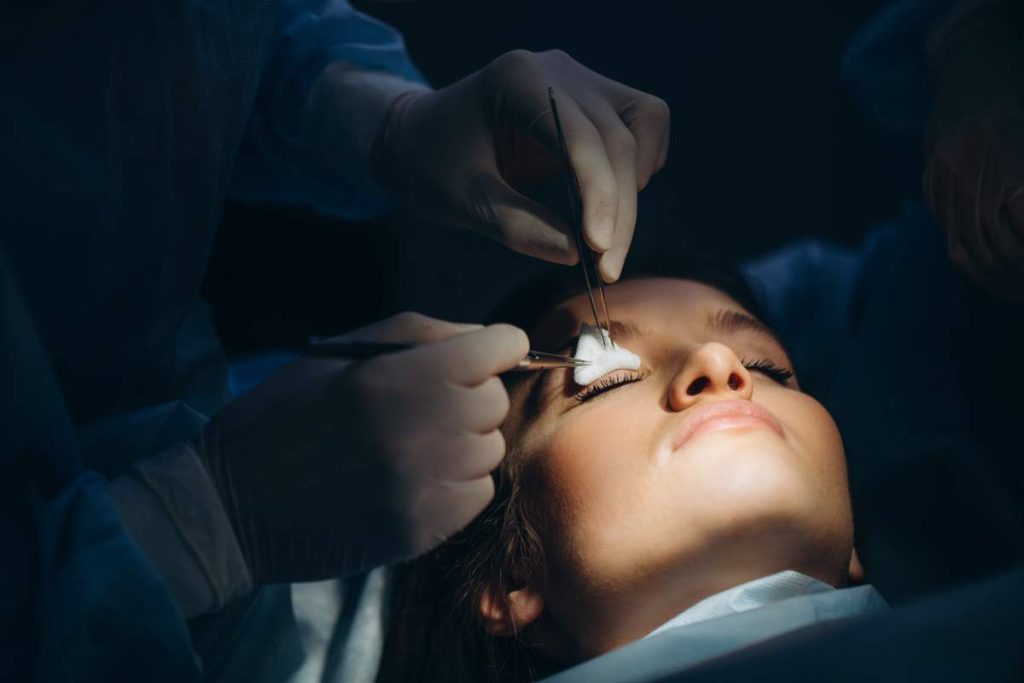 Surgeon and his assistant performing Blepharoplast in hospital operating room. Nose reshaping, augmentation. Rhinoplasty.