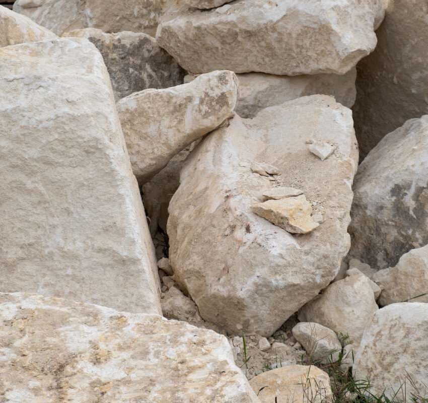 Big pile of large sand stones laying on the ground of construction site.