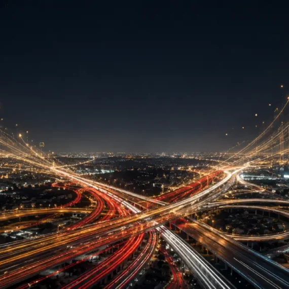 A dramatic night view of an Australian highway interchange where traffic light trails curve upward to form glowing financial graphs.